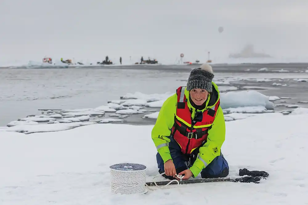Helen Czerski deploying scientific measuring devices trhough the ice on a research trip at the North Pole