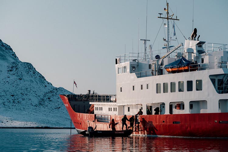 A zodiac being launched from the MV Vikingfjord Exploration Vessel in Greenland's Scorebsy Sund