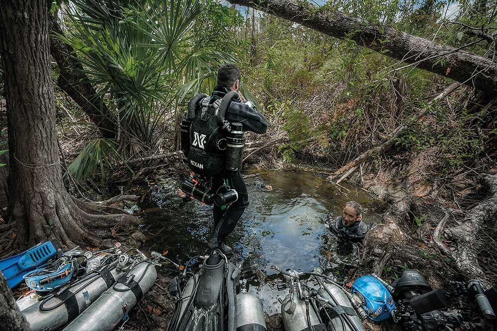 a cave diver entering cenote Kim Ha