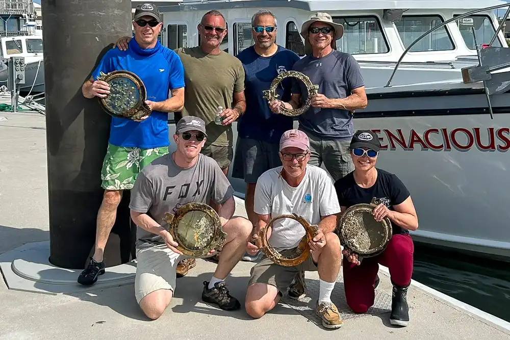 the team from atlantic wreck salvage holding portholes from the wreck of the steam ship lyonnais