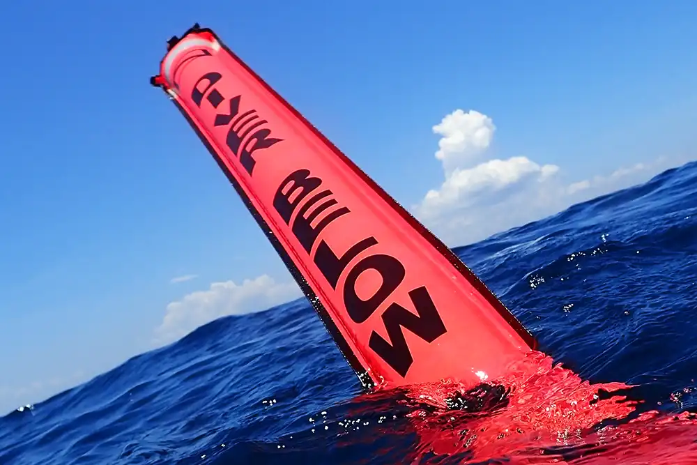 a picture of a scuba diver's delayed surface marker buoy inflated at the surface