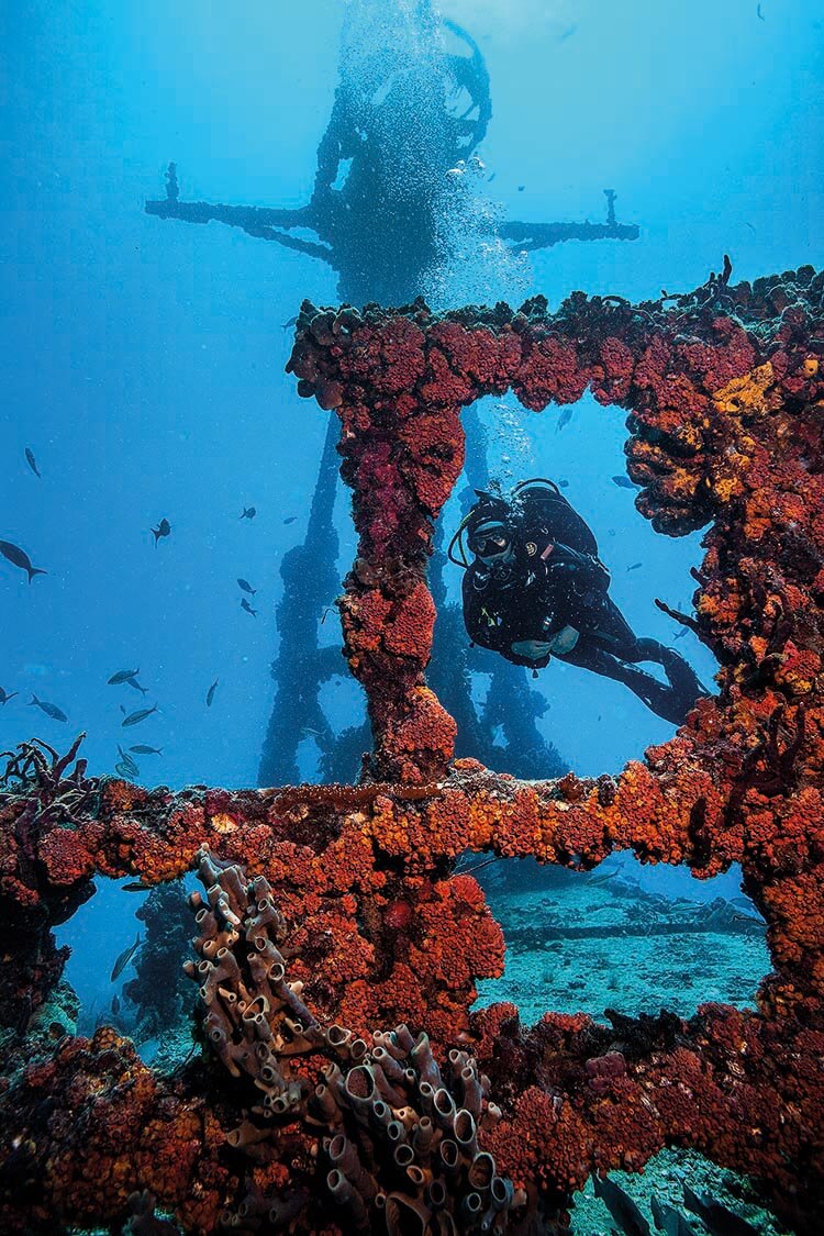 diver swimming through part of the superstructure in the wreck of the Duane