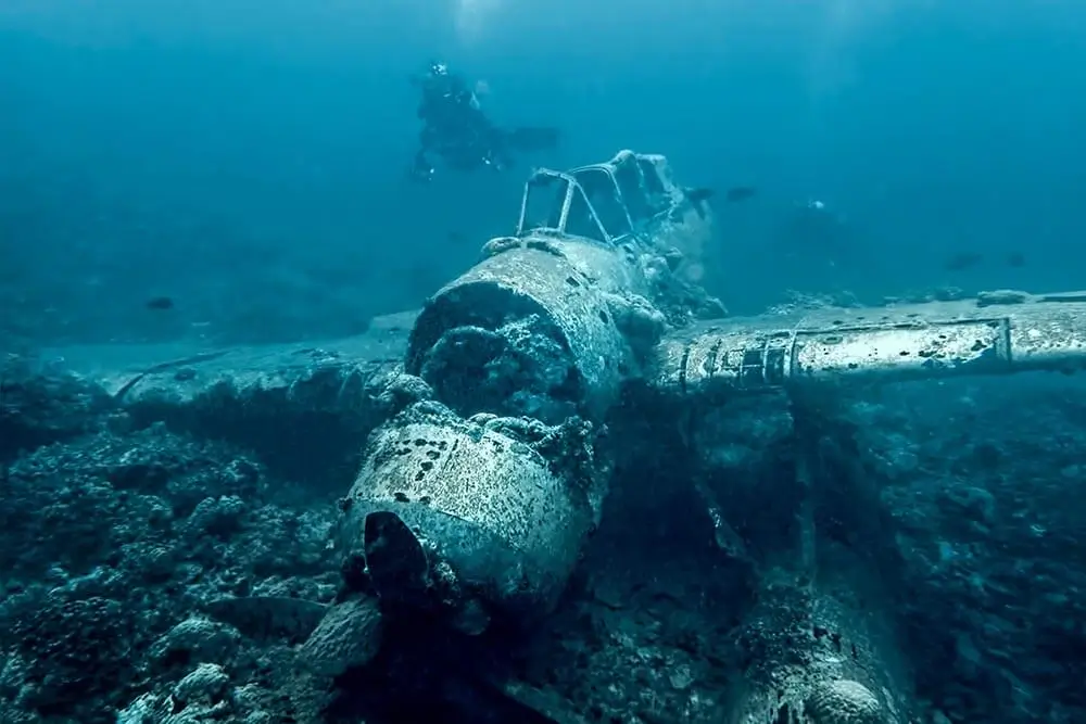 a diver approaches jake's seaplane in palau, a sunken aichi navy float plane from the second world war