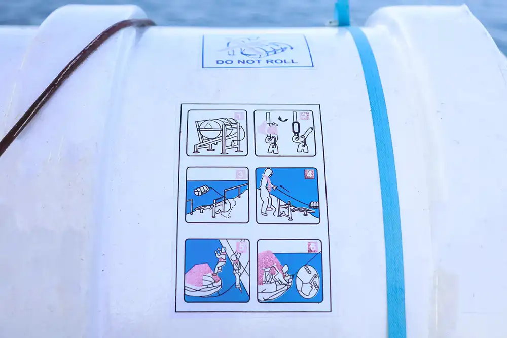 a sticker on the outside of a life raft showing the deployment instructions