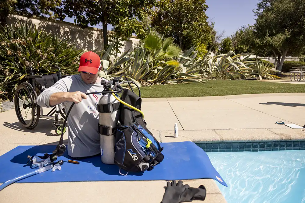 a disabled double-amputee diver setting up his scuba diving gear