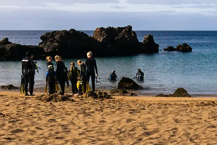 scuba divers and snorkellers at playa chica beach in lanzarote