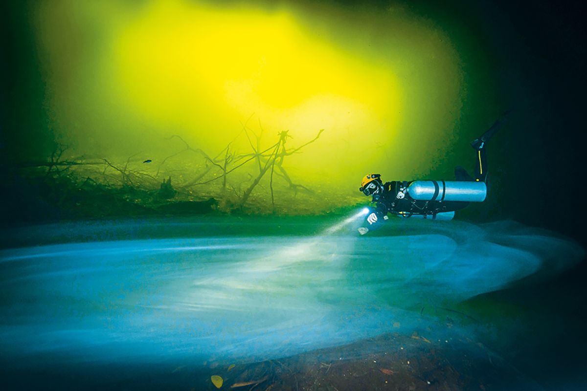 diver hovering over green cloud of Hydrogen Sulphide in Cenote La Orquidea