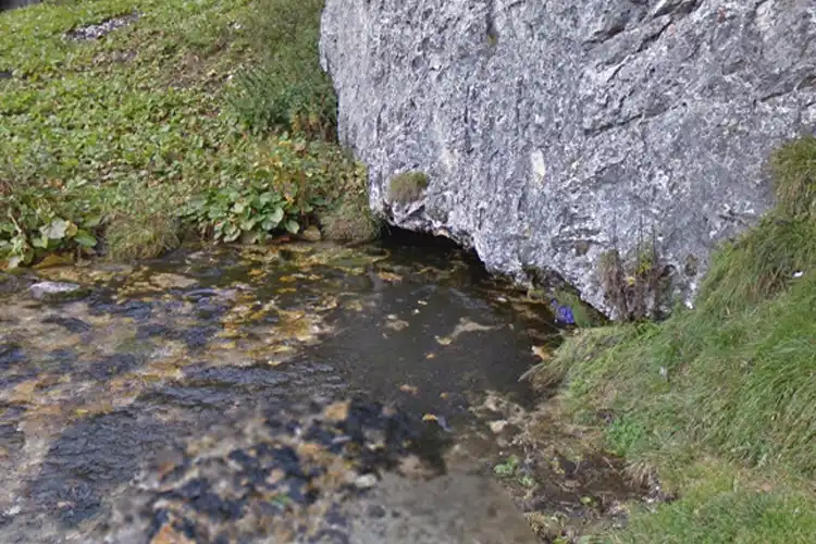 the narrow opening of the cave at sorgente del brenno