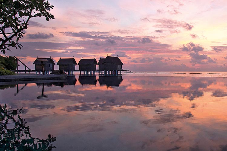 sunset at the constance moofishi hotel cabins in the maldives