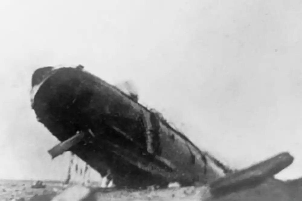 The Arcadian's stern rises from the water as she sinks. Men can be seen hanging on ropes to the ship's port side